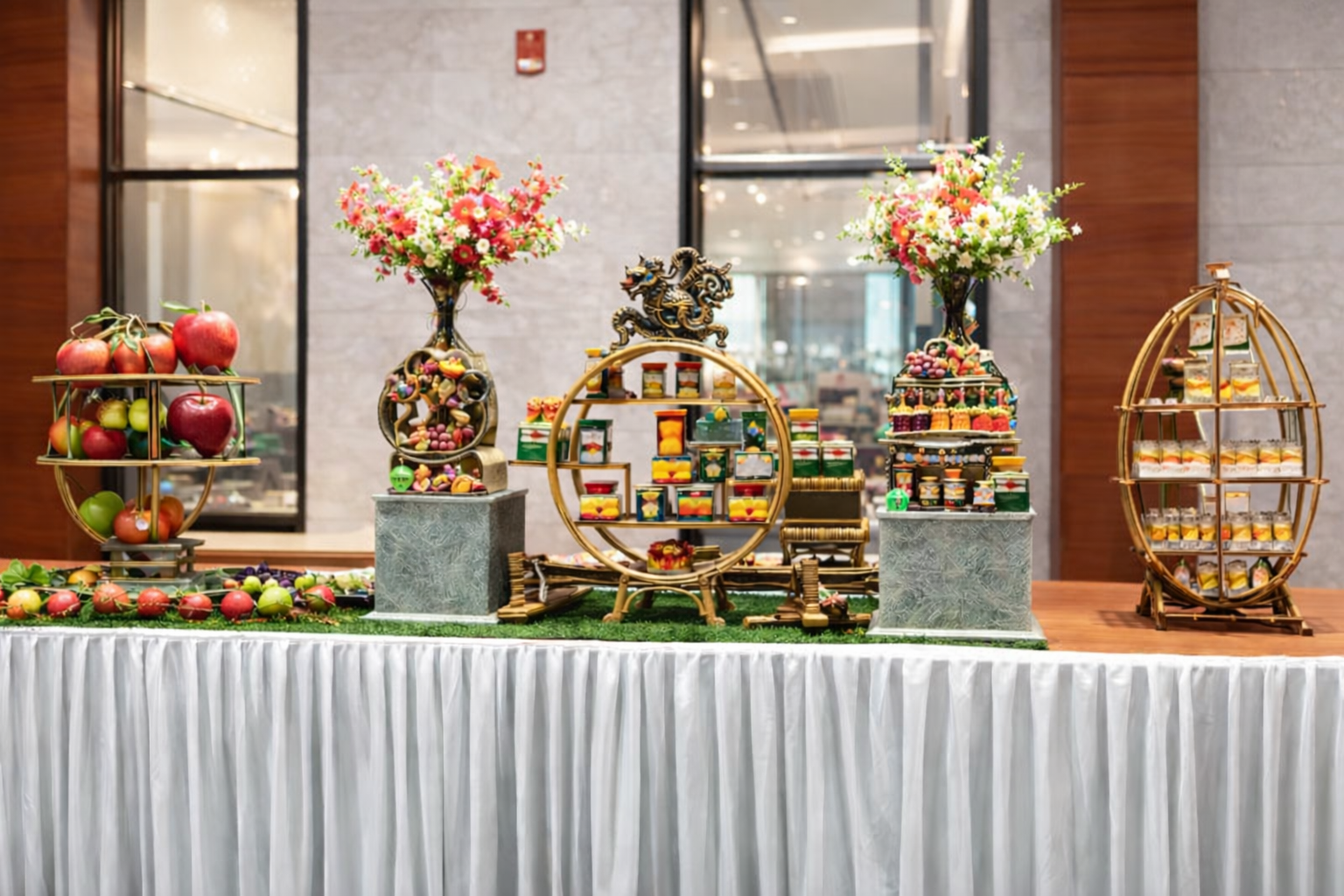 Premium dessert and fruit display setup with floral decoration in a luxury convention hall event